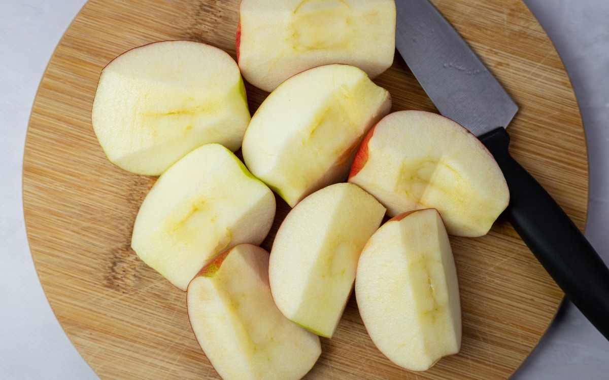 Fresh apple slices on a clean cutting board in a kitchen