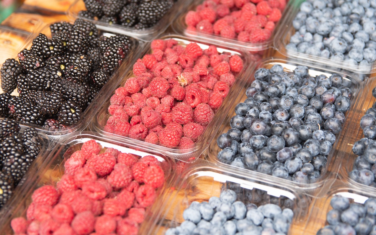 Assorted fresh berries stored in clear containers