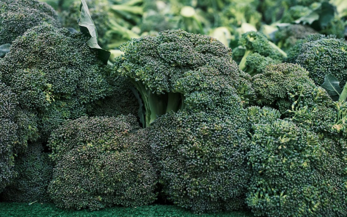 Fresh green broccoli heads displayed at a produce market
