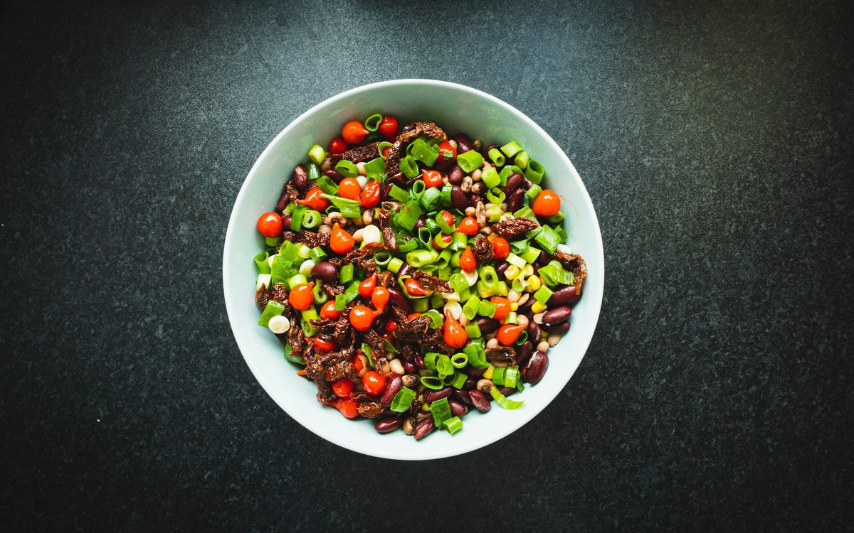 Colorful mixed bean salad in a bowl with fresh vegetables