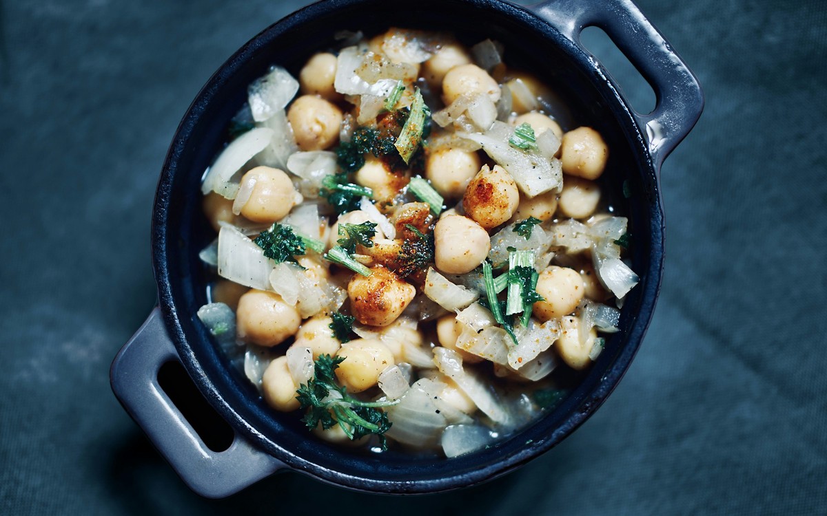 Cooked chickpeas with vegetables in a small dark serving pan