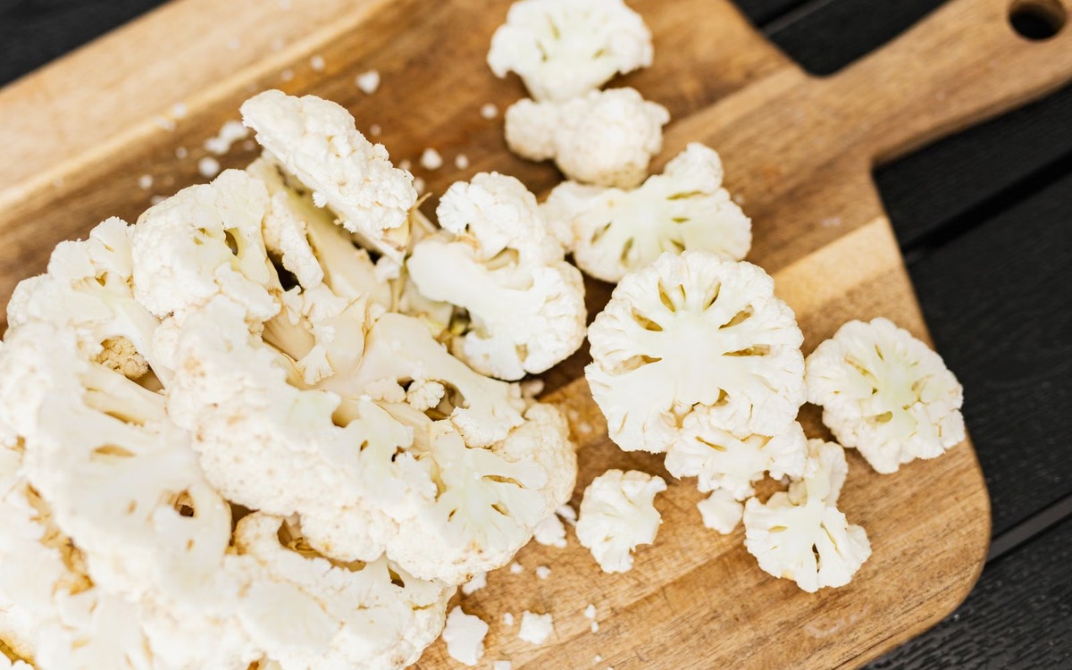 Fresh cauliflower florets cut on a board and ready for blanching and freezing