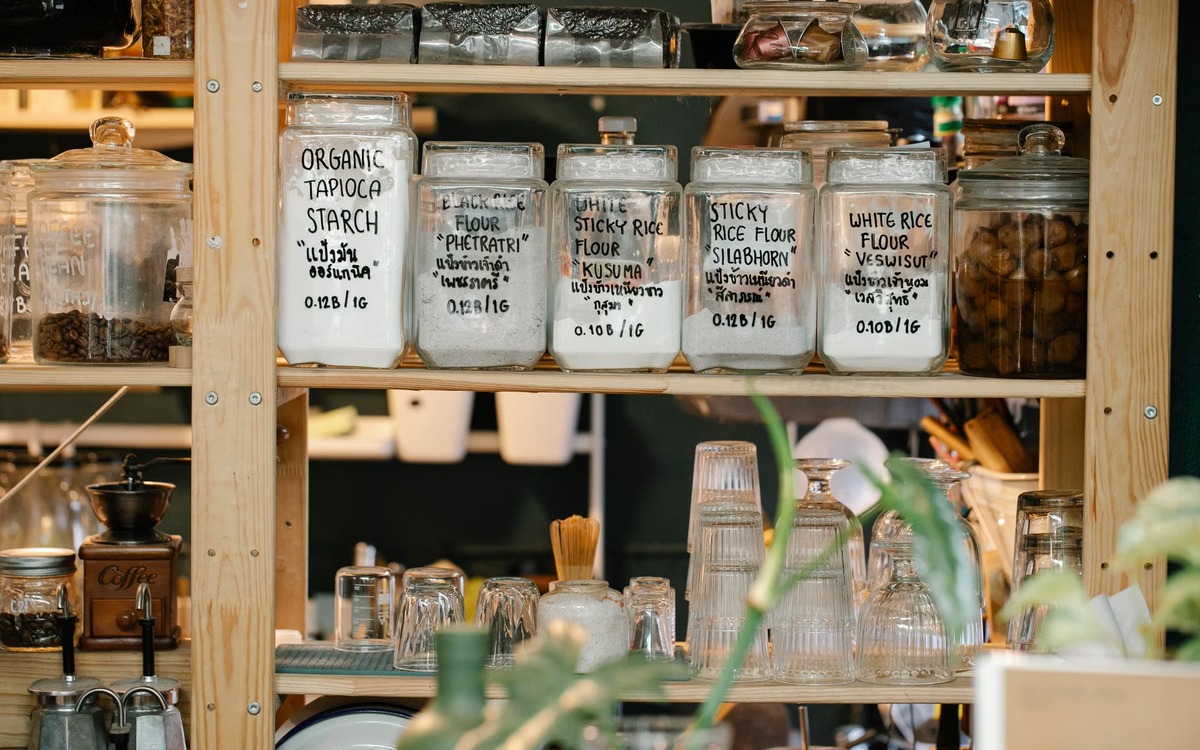Dry baking ingredients including flour stored in lidded glass jars on pantry shelves