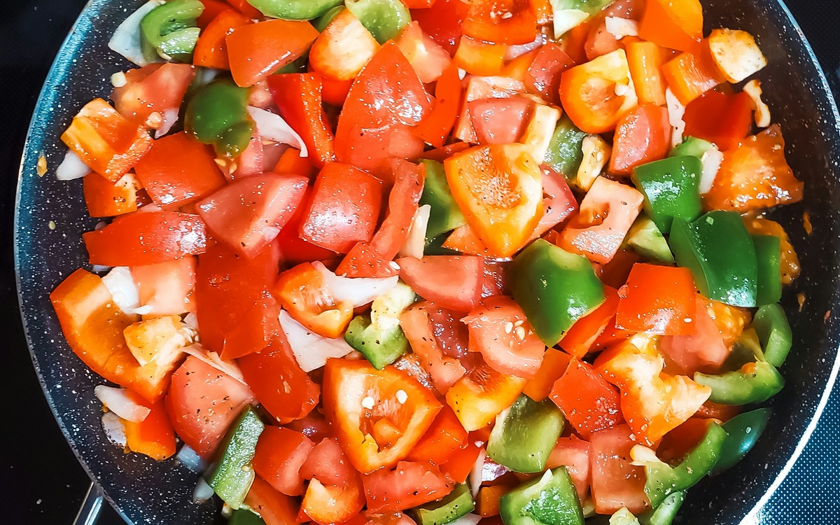 Vegetables cooking in a frying pan on a home stove