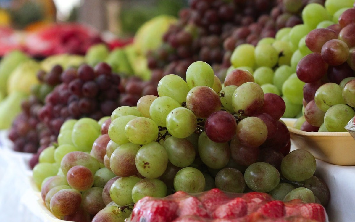 Fresh red and green grapes displayed at a market for shoppers to choose from