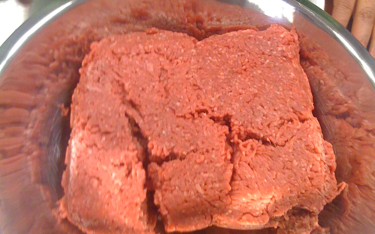 Packages of raw meat displayed in a refrigerated grocery case
