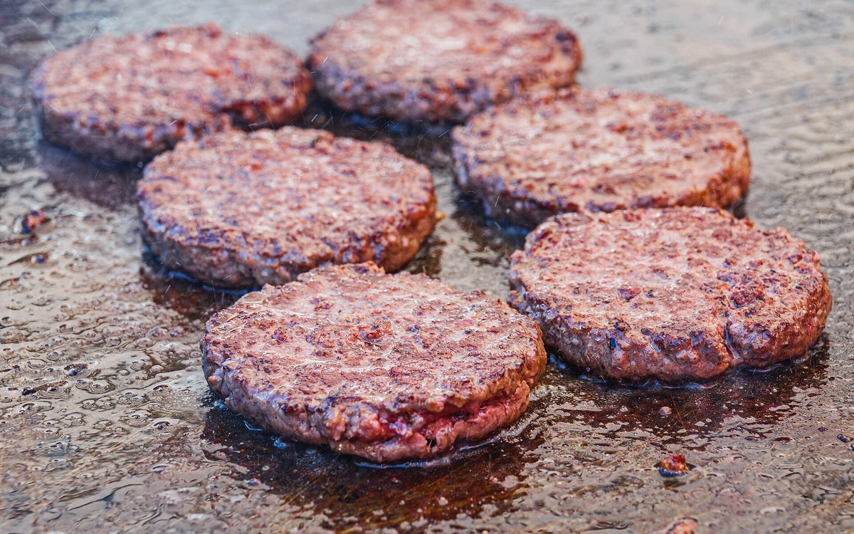 Raw ground beef patties prepared on a tray before cooking