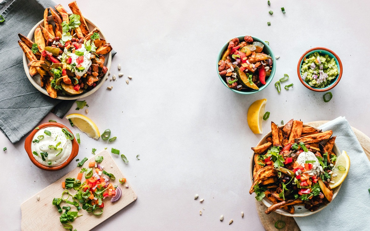 Several colorful prepared lunch bowls with vegetables and grains