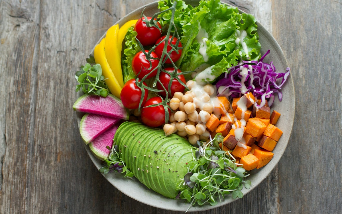 Colorful vegetable and chickpea salad bowl with avocado and sweet potato