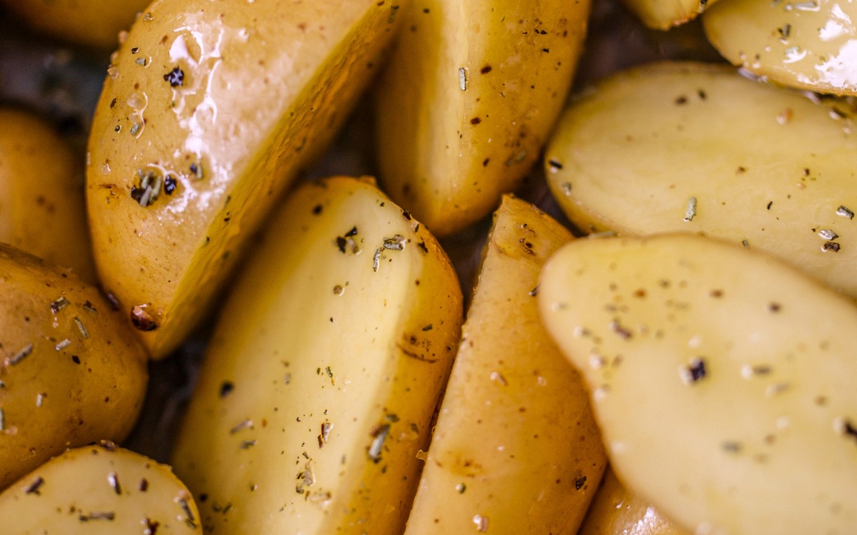 Seasoned potato wedges prepared for roasting to a golden rather than very dark brown color