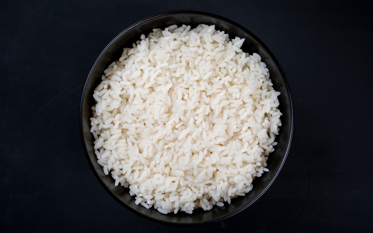 Freshly cooked white rice in a dark bowl