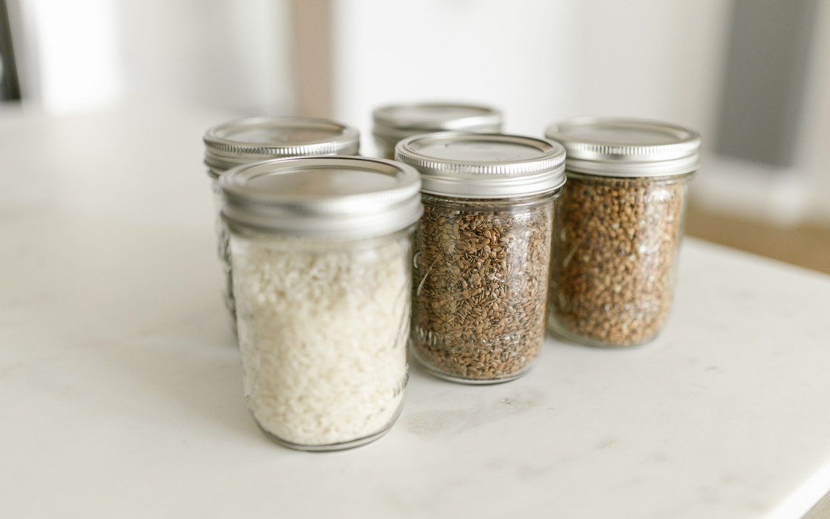 Dry rice and other grains stored in sealed glass jars on a kitchen counter
