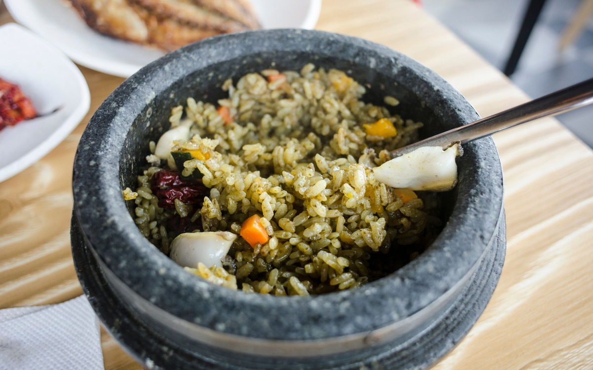 Hot cooked rice dish served in a stone pot