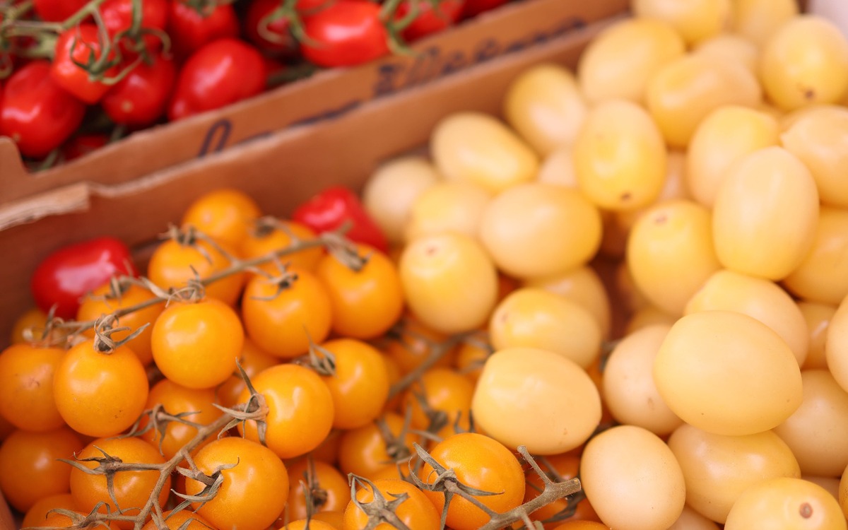 Colorful ripe tomatoes displayed at a market for shoppers to choose from