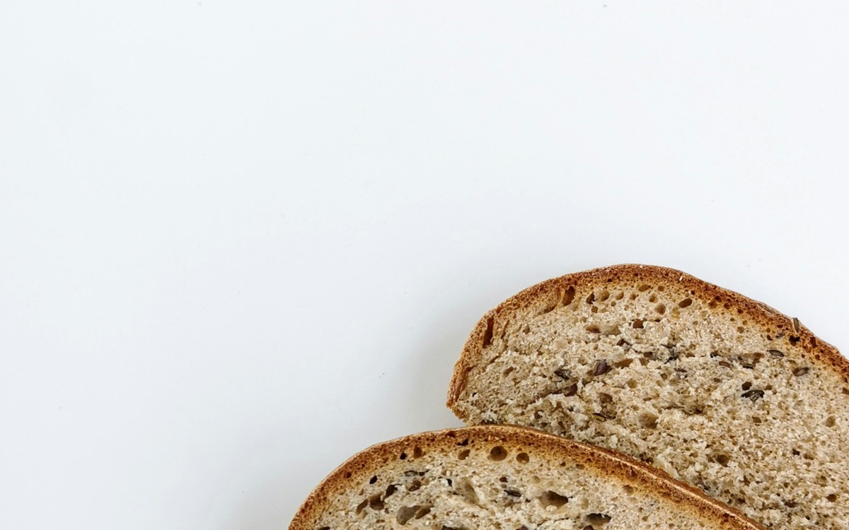 Sliced whole grain bread loaf on a light surface