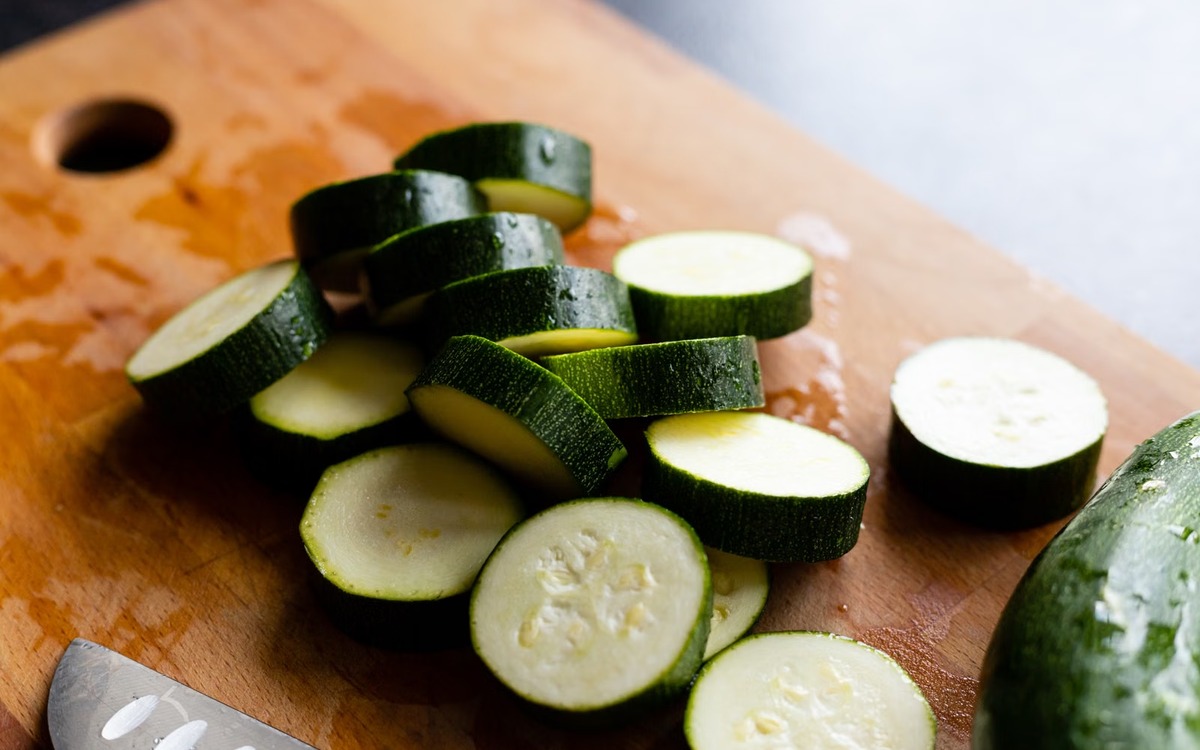 Fresh zucchini sliced on a wooden cutting board